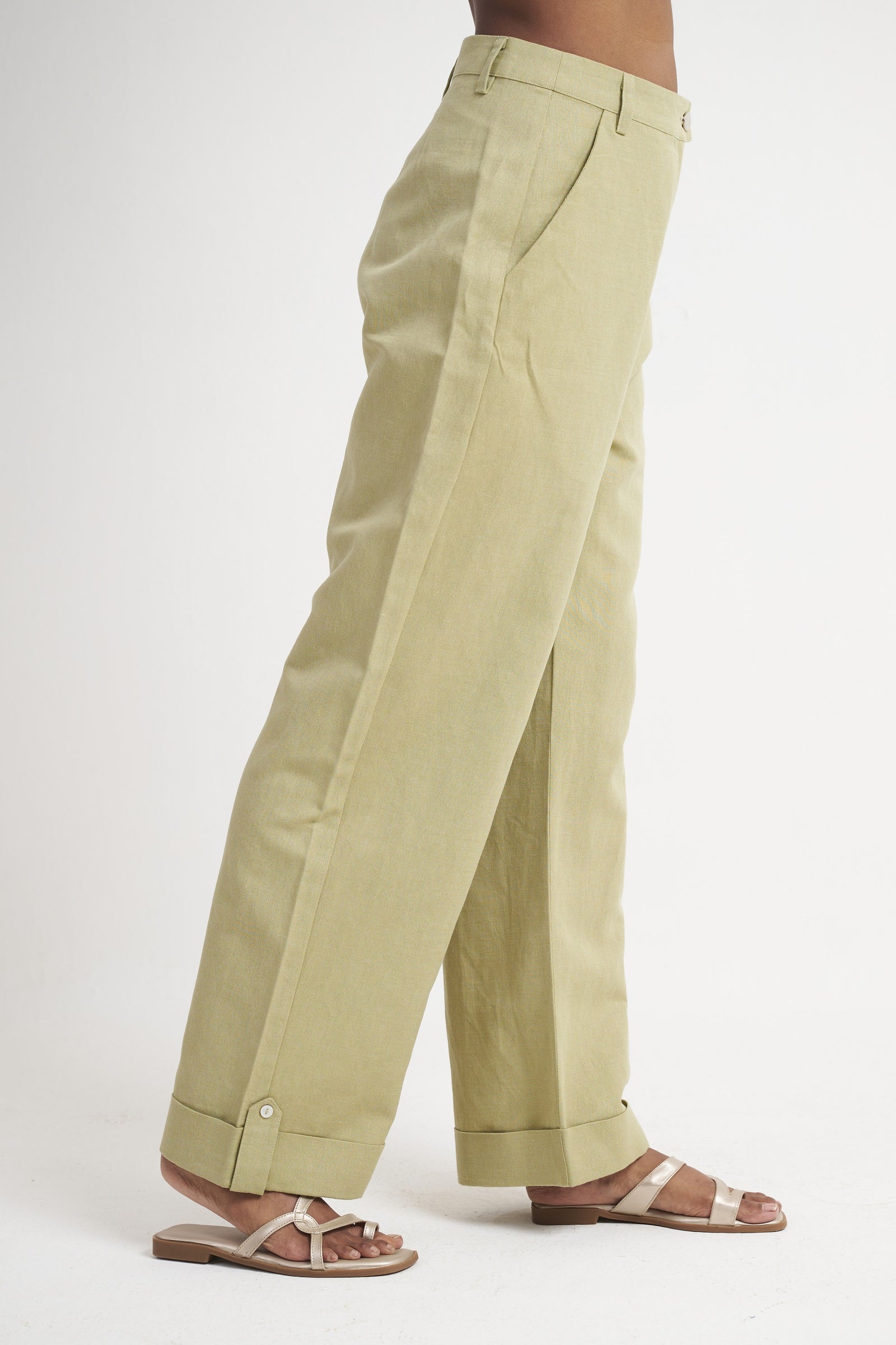 Buttoned turn-up cuff detail on sage green tailored trouser