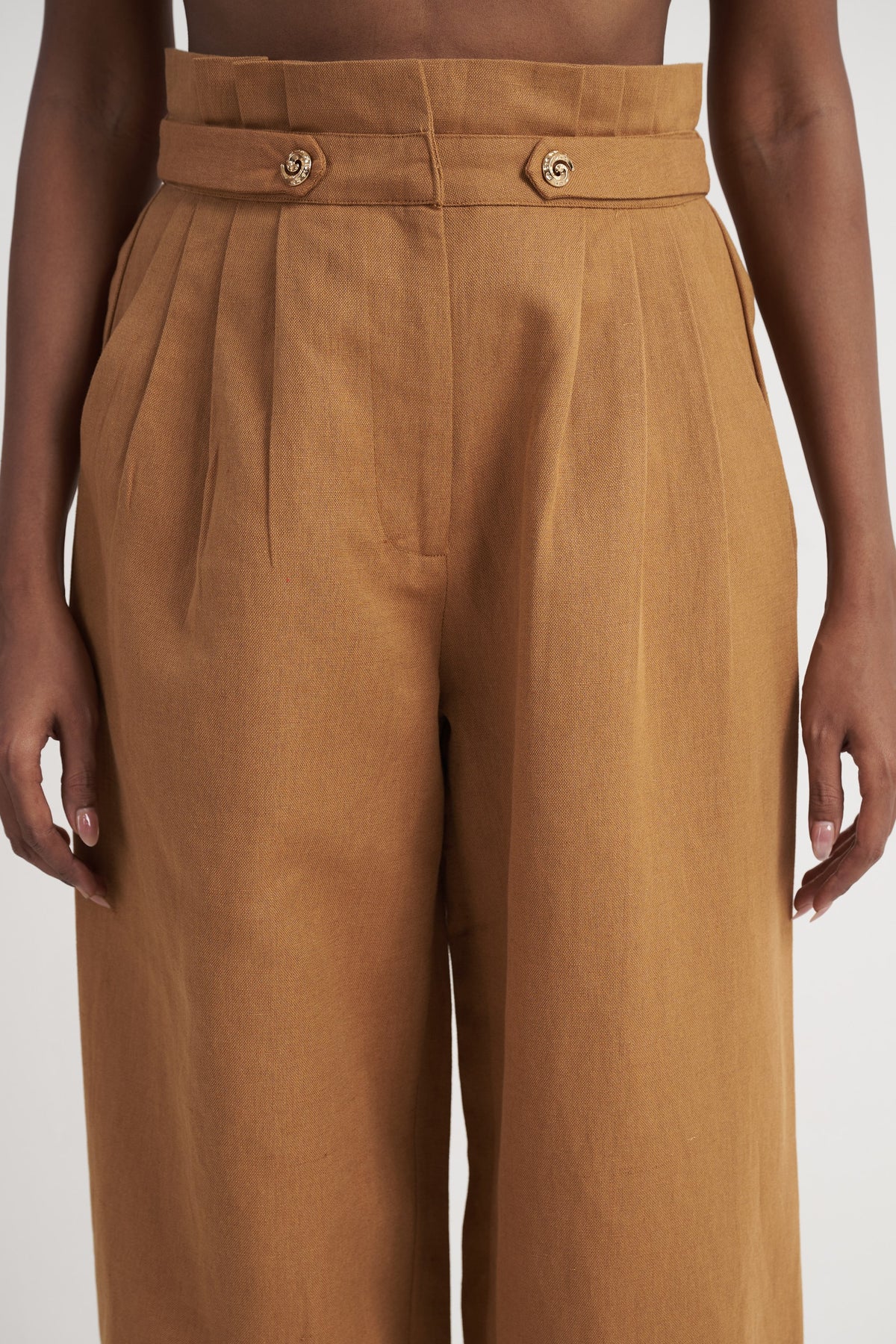 Zykaz High-Rise Pleated Tapered Trouser in Chipmunk — banded waist and button tab detail