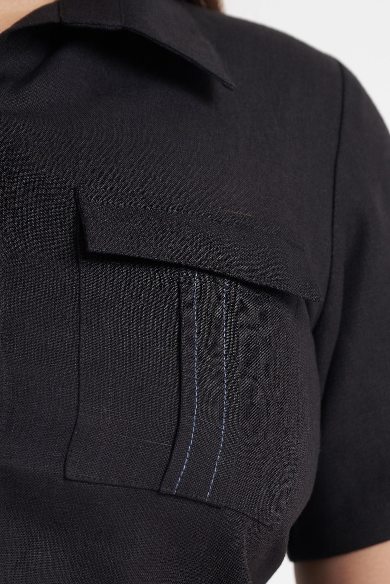 Flap pocket and contrast topstitch detail on black utility crop shirt